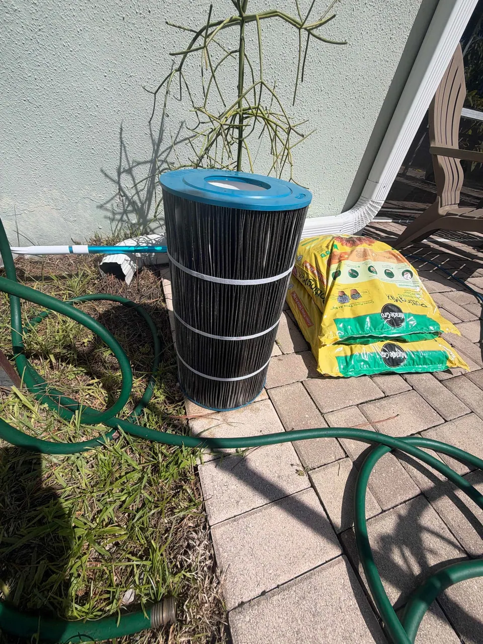 A pool cartridge filter caked black with debris before cleaning